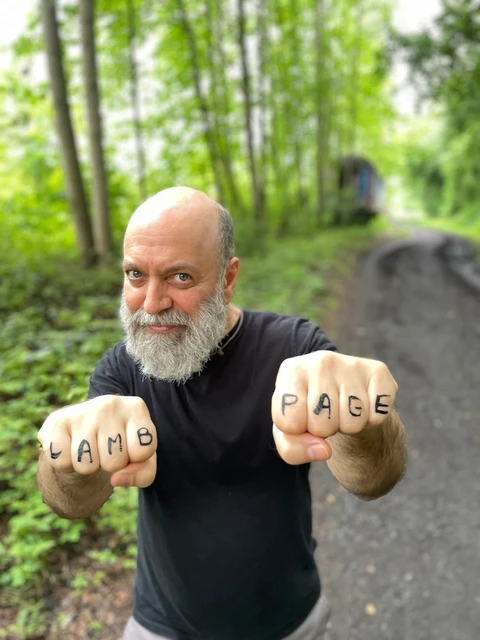 david showing his knuckles, which have L A M B P A G E written on them