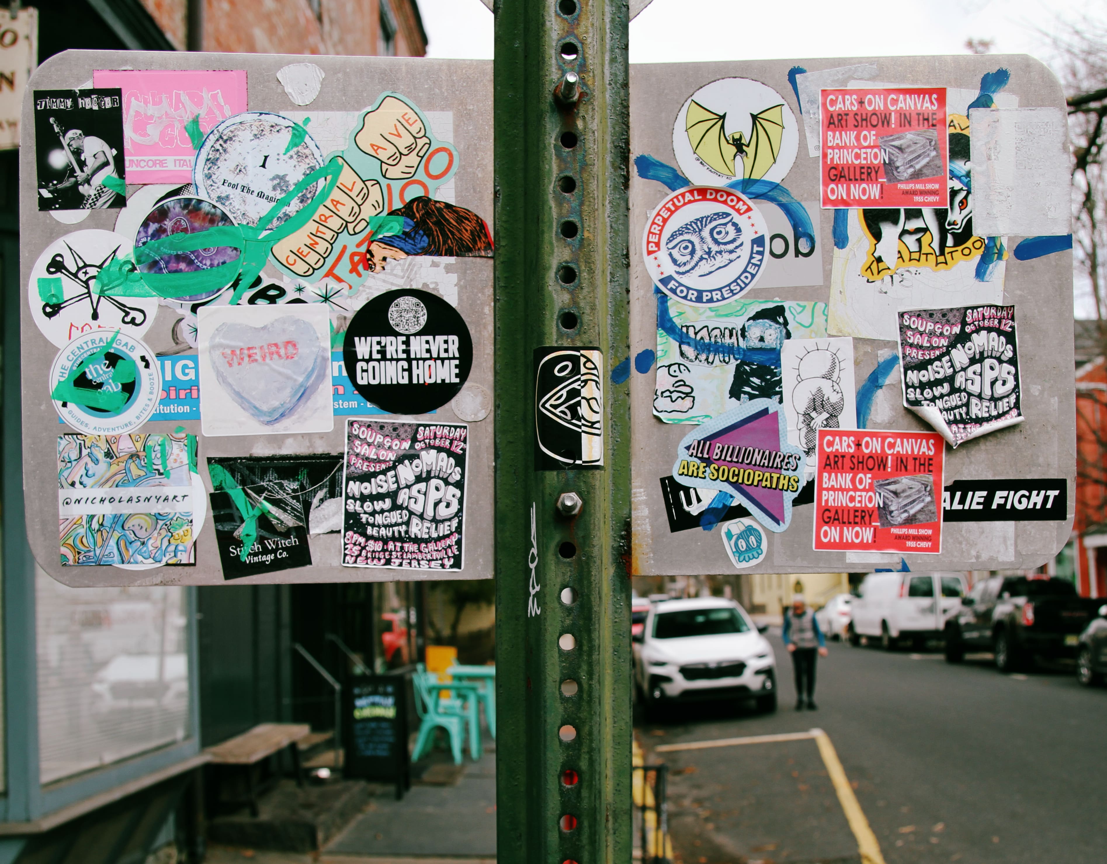 An array of stickers on the back of a street sign.