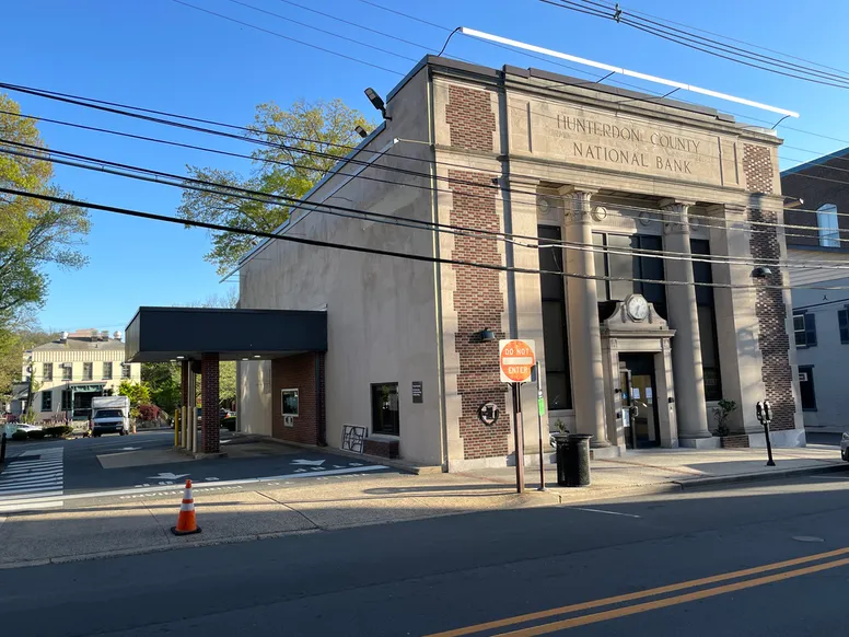 a prominent bank building with tall columns and a drive through