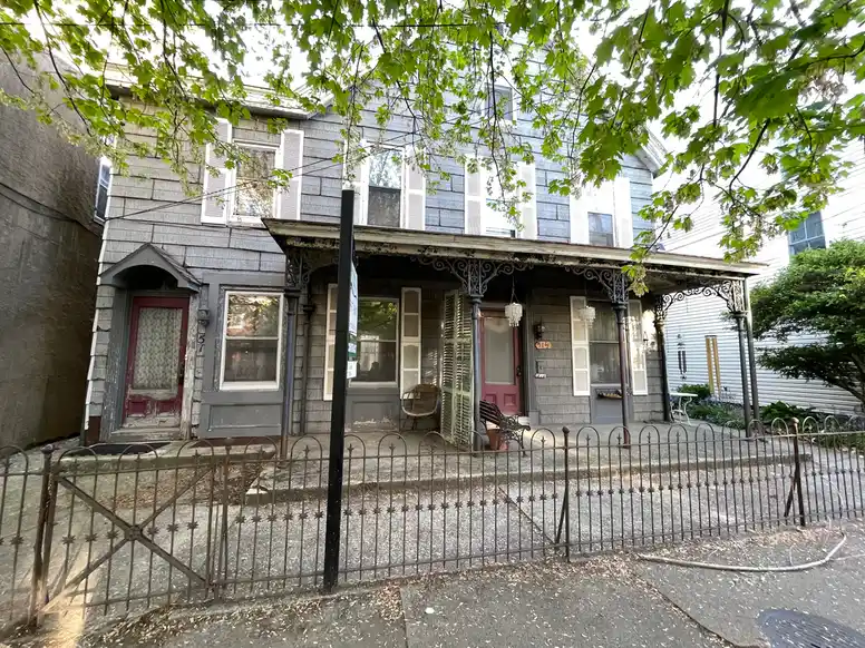 a slightly dilapidated old house with two doors on the front