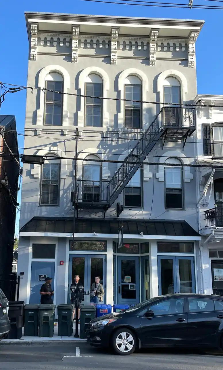 a classic old three-story building with tall windows and fancy adornments