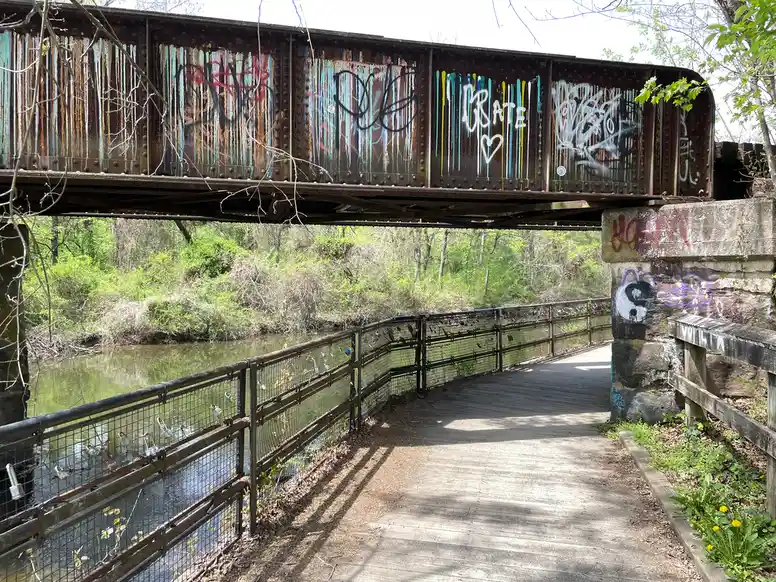an old railroad tressle with spray paint on it