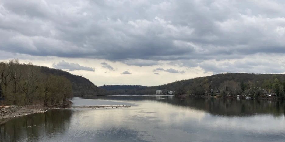 the river with hills on each side and a dramatic cloudy sky