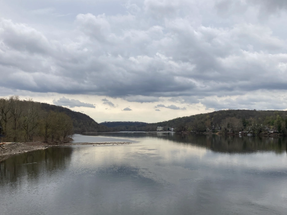 the river with hills on each side and a dramatic cloudy sky