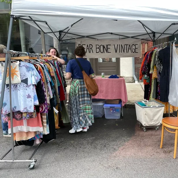a festival goer looks through a rack of clothes