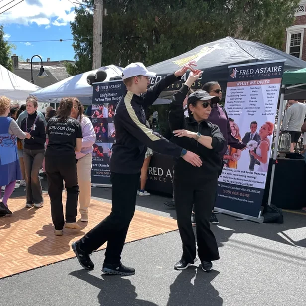 a man and woman dancing together in the street