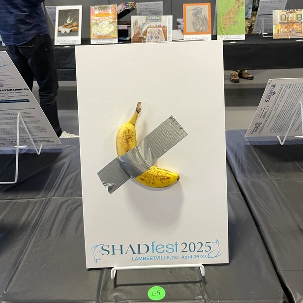 a banana duct taped to a poster board