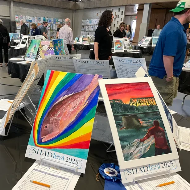 posters on tables with people walking around and looking at them