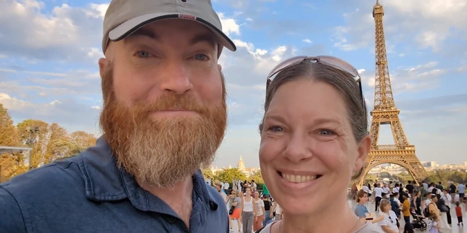 Cindy and Eddie of Squeeze the Day stand before the Eiffel Tower in Paris