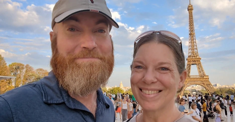 Cindy and Eddie of Squeeze the Day stand before the Eiffel Tower in Paris