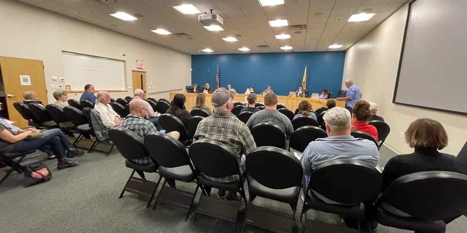 a group of people listening to Jeff give public comment