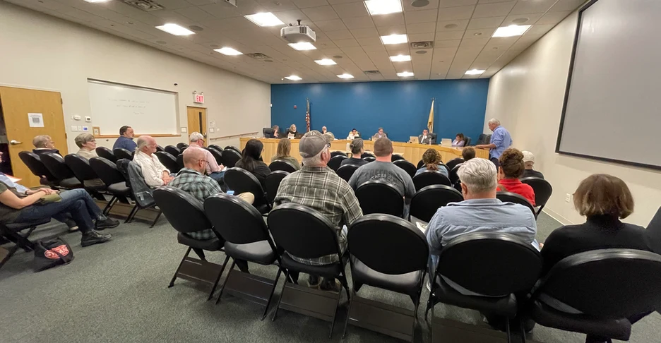 a group of people listening to Jeff give public comment