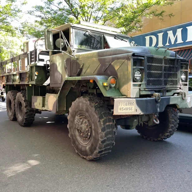 a large camouflaged military vehicle with giant black tires