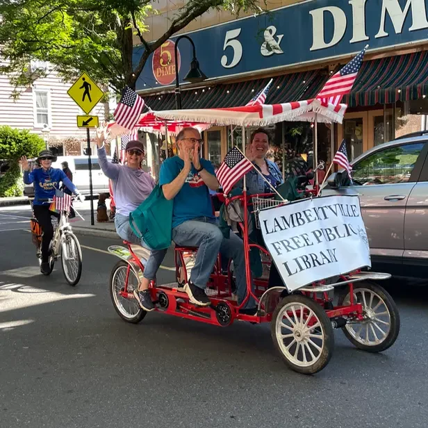 a four-seater, four-wheeled, pedel-powered cycle with a library sign on it