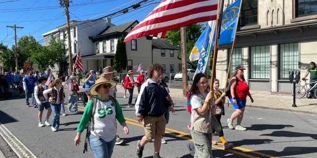 Girls Scouts march down Main Street led by several girls holding flags
