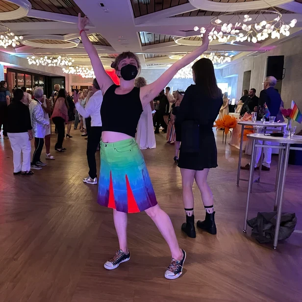 Gwenn standing arms outstretched on a ballroom dance floor