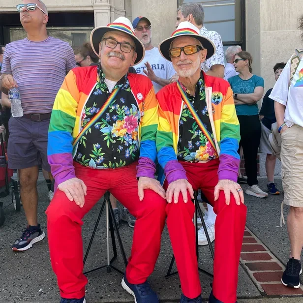 Frank and Chet wearing matching rainbow outfits