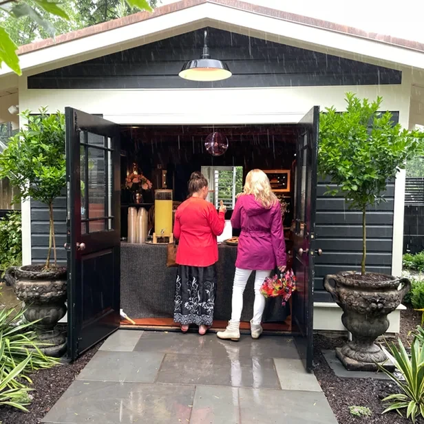 two guests sample refreshments being served by the Dance Shed entrance