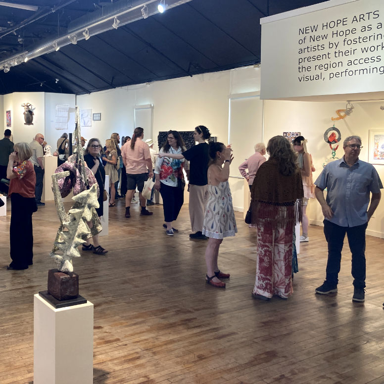 a group of people mingling in a gallery full of art