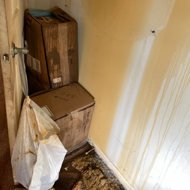 damaged boxed sit piled behind the bedroom door