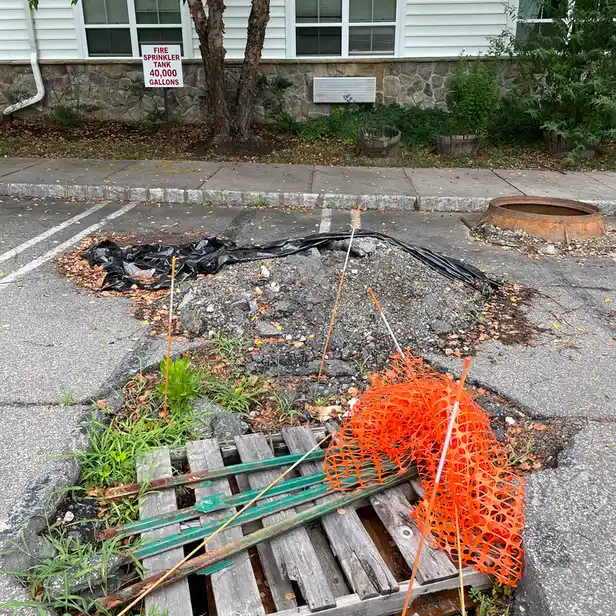 a hole in the parking lot that takes up two parking spaces