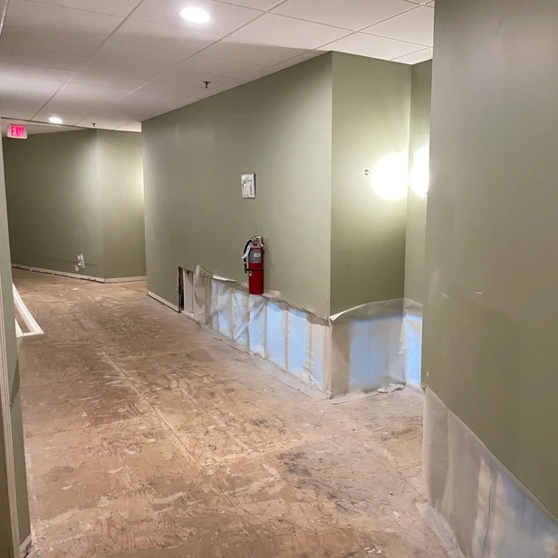 interior hallway with drywall cut away where the floor and wall meet