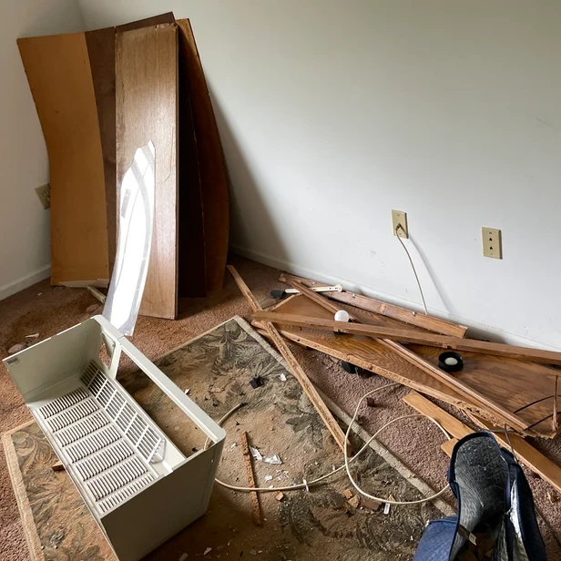 damaged wood furniture is broken and piled in the corner