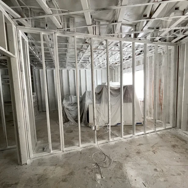 a gutted apartment with white painted studded walls