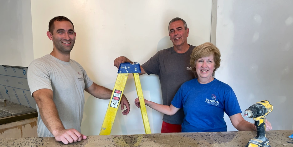 the Zolnay family poses by a drill and ladder as they take a break during work in their soon-to-open brewery