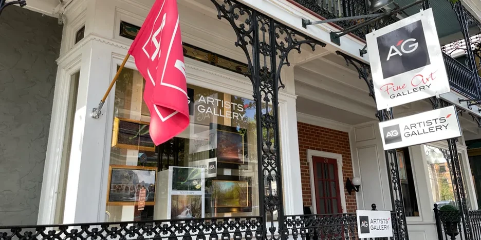 the front of the gallery with a sign and flag on display