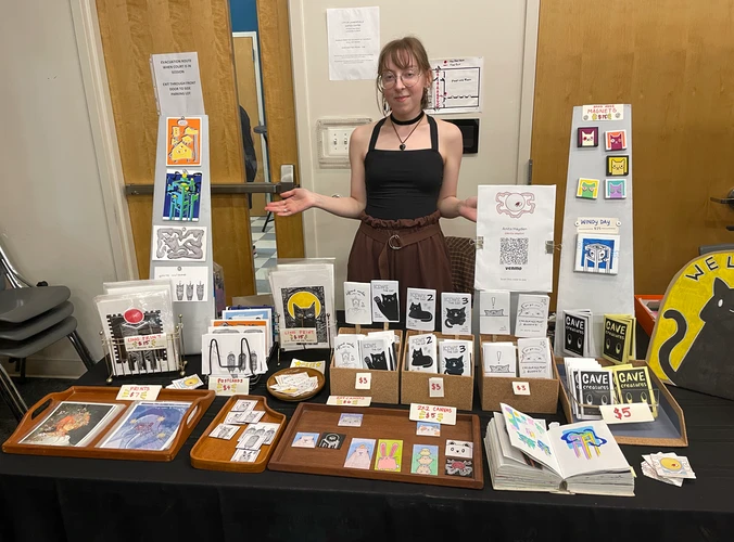 Anita stands behind a table that holds her display of art items for sale