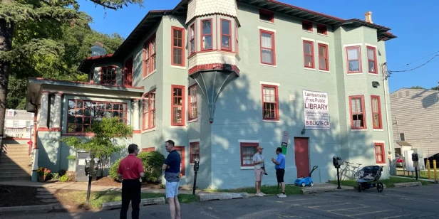 People stand and chat outside of the newly repainted library in Lambertville, NJ.