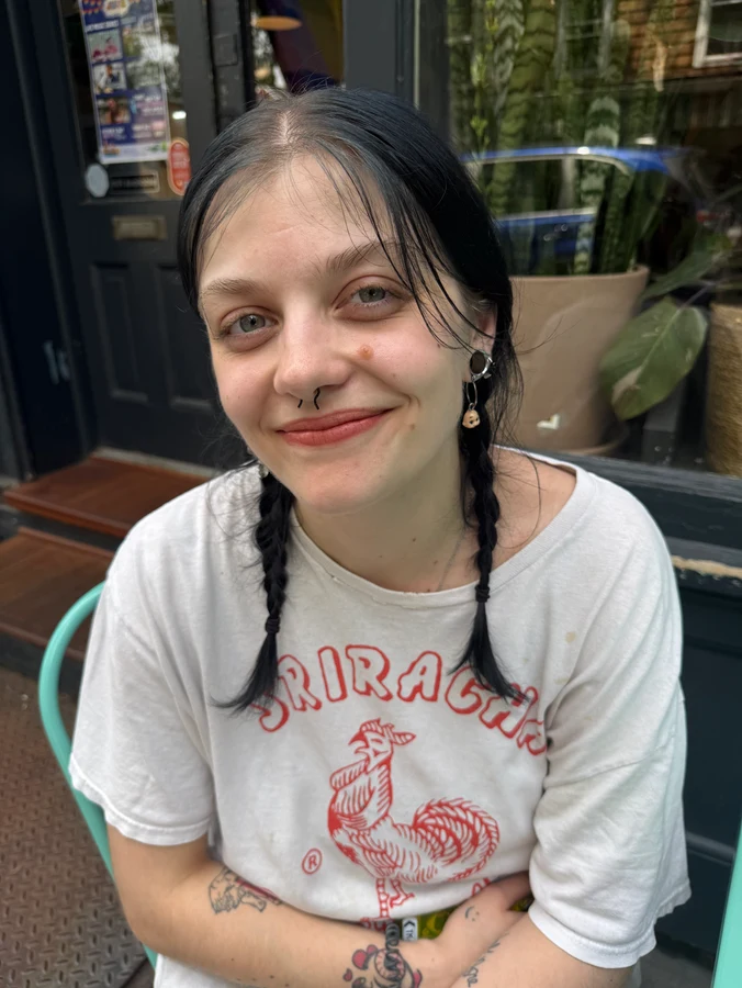 a person sitting and smiling at a table outside of Union Coffee