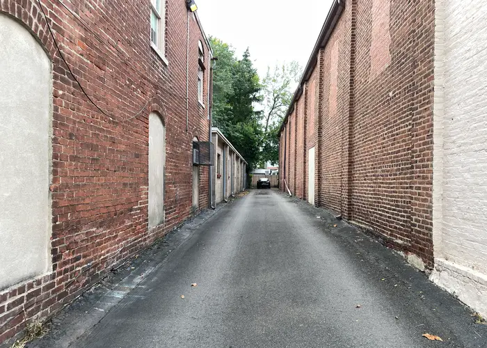 a sign is barely noticable at the end of a long allyway