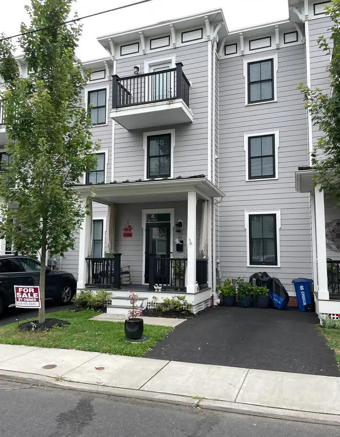 an attached townhouse with a balcony on the third floor