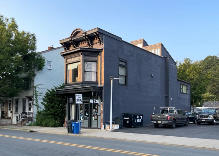an old firehouse next to a gas station on main street