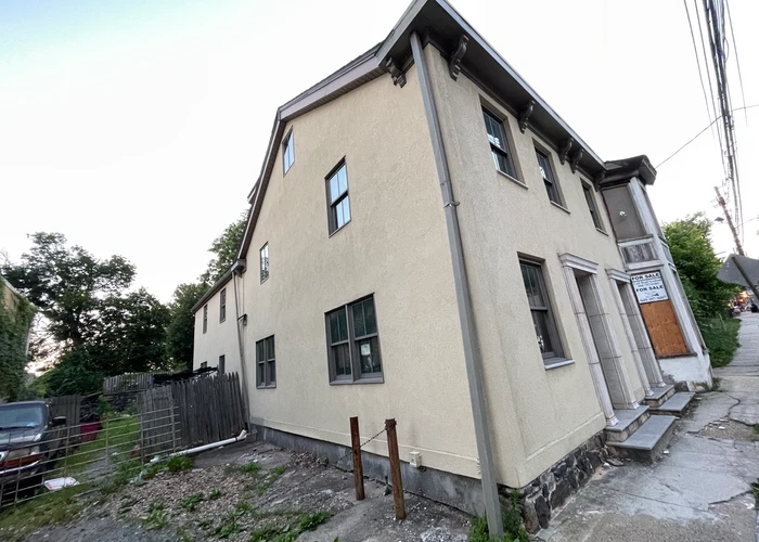 an old, abandoned building with a FOR SALE sign on it