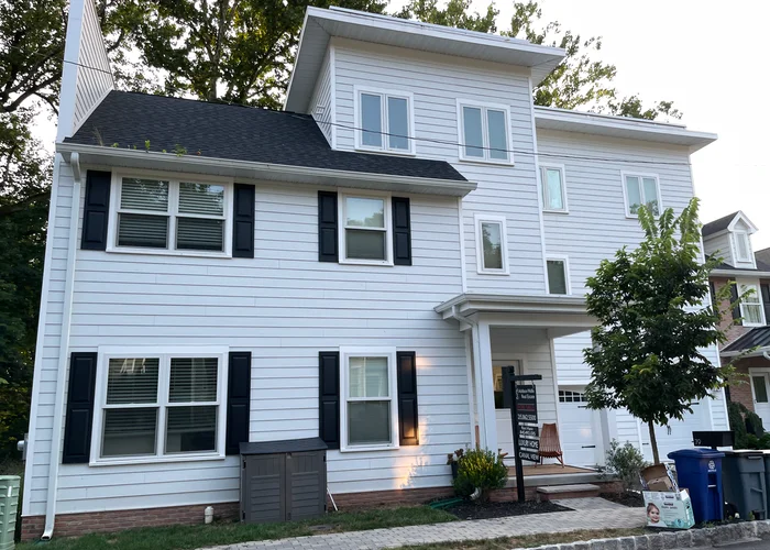a new, large, townhouse with white siding 