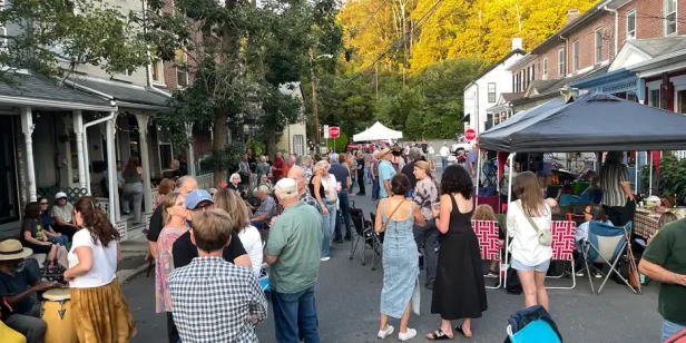 groups of people gathered together on the block, chatting and enjoying the music