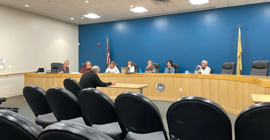 a man sits before the committee and presents his application