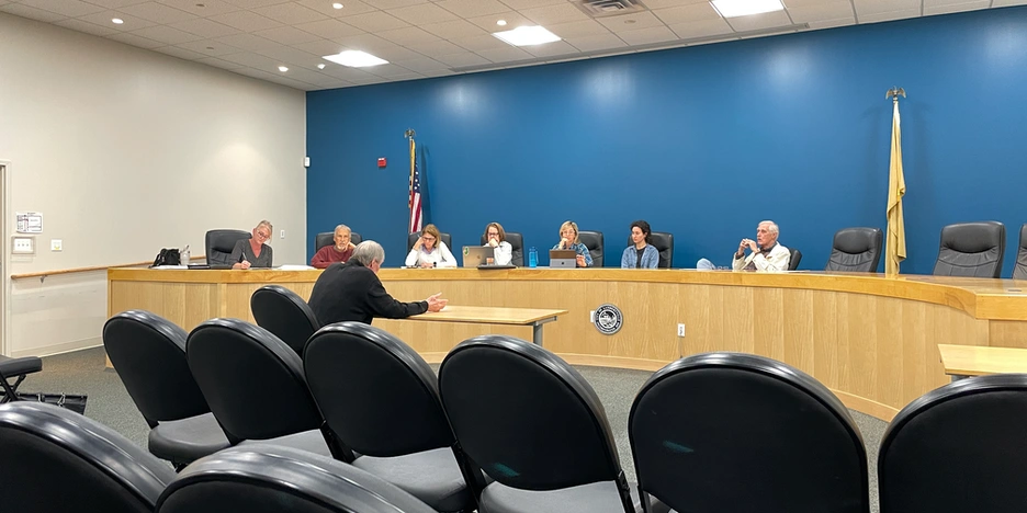 a man sits before the committee and presents his application