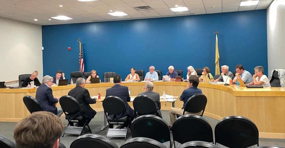 several men sit at a table and present their application to the planning board