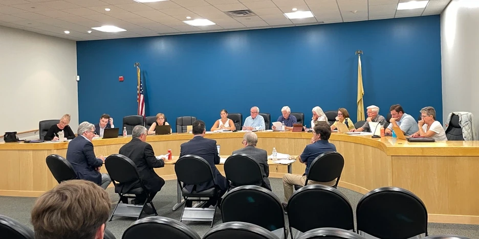 several men sit at a table and present their application to the planning board