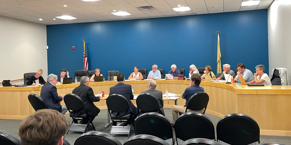 several men sit at a table and present their application to the planning board