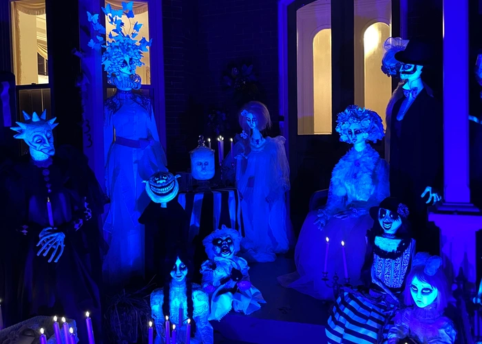 glowing haunted figures on the front steps of an old brick house