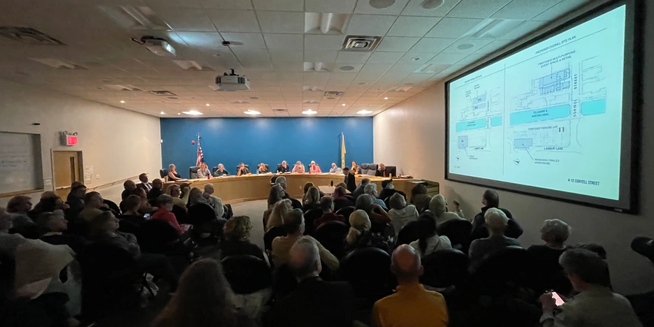 a meeting room filled with people looking at a projected image on a screen