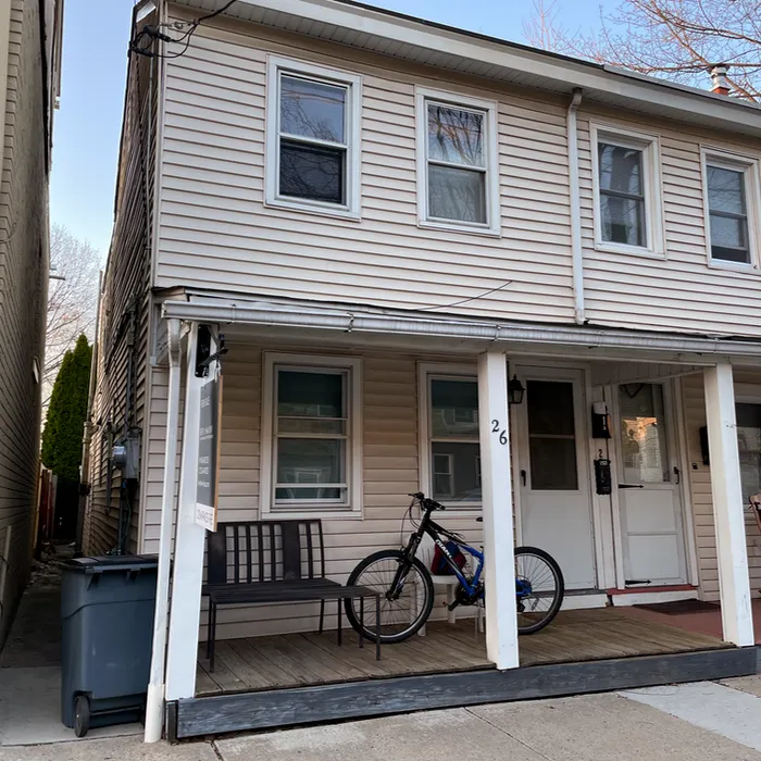half of a small duplex with a porch in front